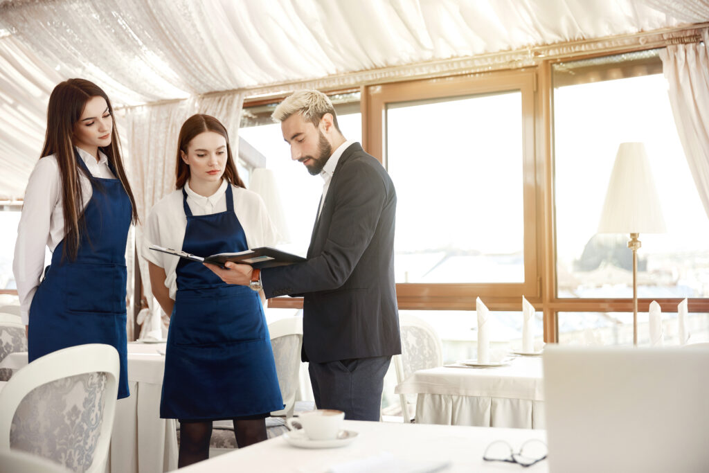 Director of a restaurant is giving work instructions to waitress